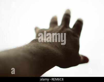 Hand erreichen für Licht, brillantes Licht mit Hand silhouetted, Hand des Menschen mit weißem Hintergrund Stockfoto