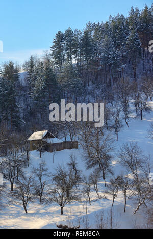 Ferienhaus aus Holz in sonniger Winterlandschaft Stockfoto