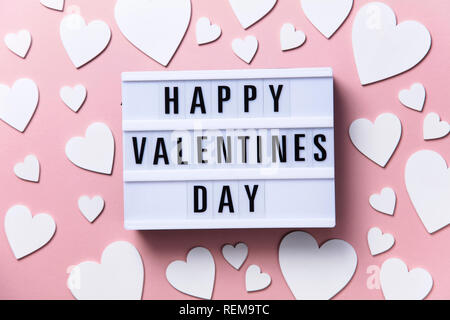 Happy Valentin's Day lightbox Nachricht mit weißen Herzen auf einem rosa Hintergrund Stockfoto
