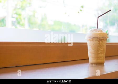 Blended Kaffee ist beliebt in Asien, in Kunststoff Glas verpackt. Ist eine erfrischende und kühlen Drink auf einen hölzernen Tisch gelegt. Stockfoto