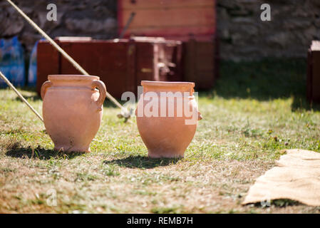 Lehm Töpfe stehen in der Mitte der mittelalterlichen Garten. Siedlung auf ein mittelalterliches Dorf. Reenactment Demonstration und Erholung im Sommer. Stockfoto
