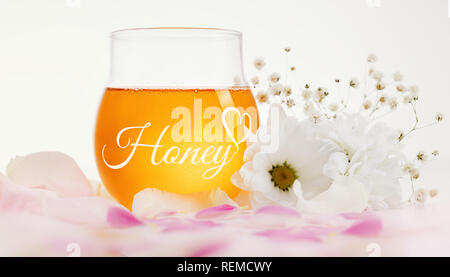 Honig und Blumen auf einem hölzernen Hintergrund. Stockfoto
