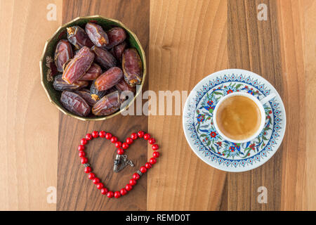 Türkischer Kaffee, Termine und herzförmige Rosenkranz auf braun Tabelle Ansicht von oben Stockfoto