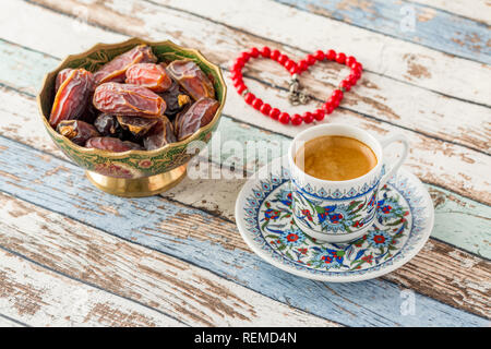 Türkischer Kaffee, Termine und herzförmige Rosenkranz auf Türkis Tabelle Seitenansicht Stockfoto