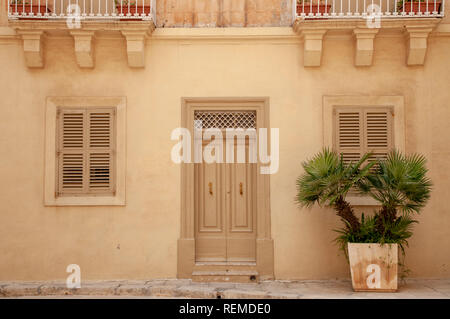 Typisches Haus Fassade aus Kalkstein und Rendern mit hölzernen Tür und Fensterläden in Mdina, Malta. Stockfoto