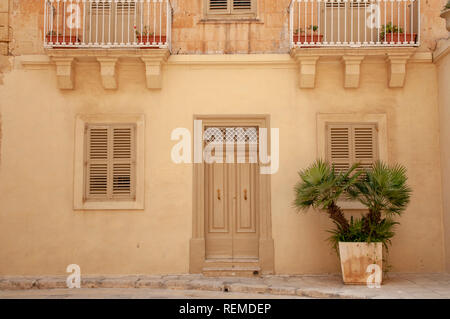 Typisches Haus Fassade aus Kalkstein und Rendern mit hölzernen Tür und Fensterläden in Mdina, Malta. Stockfoto