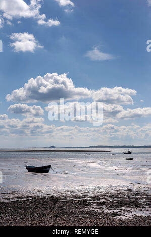 Boote von Heiligen Insel mit Bamburgh Castle im Hintergrund Stockfoto