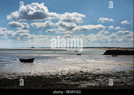 Boote von Heiligen Insel mit Bamburgh Castle im Hintergrund Stockfoto
