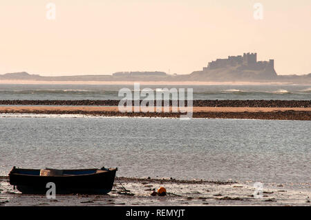 Boot vertäut aus heiligen Insel mit Bamburgh Castle im Hintergrund Stockfoto