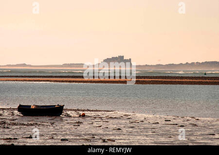 Boot vertäut aus heiligen Insel mit Bamburgh Castle im Hintergrund Stockfoto