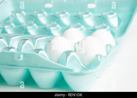 Vier weißen huhn eier in einer bunten 18-Slot ei-form Styropor Behälter. Stockfoto