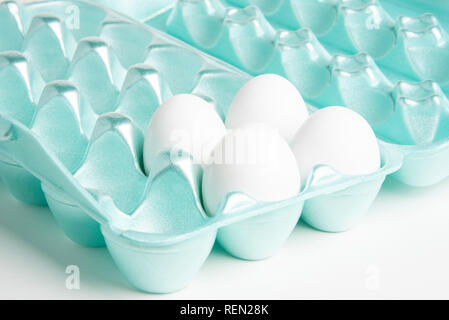 Vier weißen huhn eier in einer bunten 18-Slot ei-form Styropor Behälter. Stockfoto