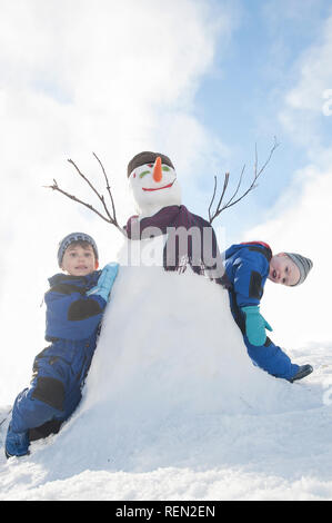 Kinder mit Schneemann, Mt Buller, Victoria, Australien Stockfoto