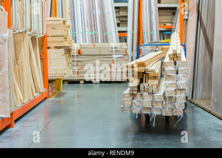 Bau Warenkorb im Gebäude zu speichern. Karren mit Boards geladen. shop von Baustoffen. Regale mit Platten, Holz und Baumaterial. geladen. c Stockfoto