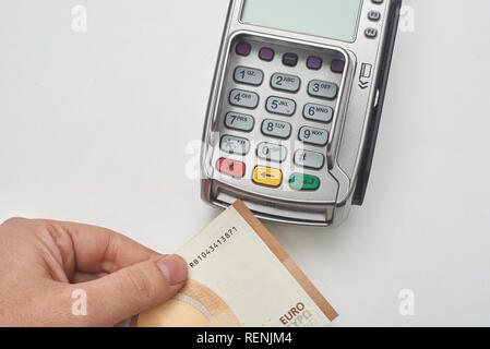 Geschäftsmann mit Payment Terminal mit Bargeld zu zahlen. Stockfoto