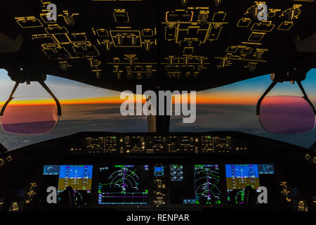 Sonnenuntergang gesehen aus dem Cockpit einer Boeing 787. Stockfoto