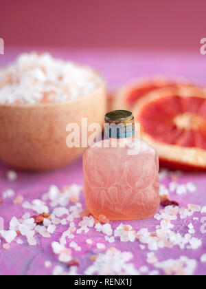 Nahaufnahme Foto des wesentlichen öls Flasche und natürlichen Zutaten auf rosa Hintergrund Stockfoto