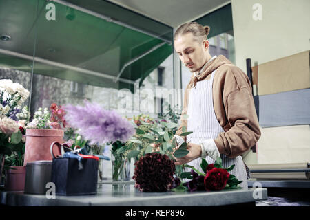 Schwere männliche Person auf der Suche nach unten bei Pflanzen Stockfoto