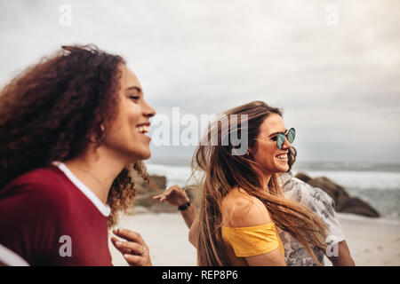 Schöne Frau mit Freunden Spaß am Strand. Gruppe von Freunden Spaß draußen am Strand. Stockfoto