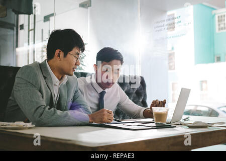 Zwei asiatische Geschäftsleute gemeinsam in ein Café. Kollegen im Café sitzen Analyse einige Dokumente. Stockfoto