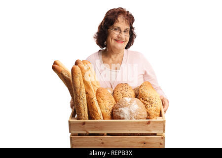 Ältere Frau mit einer Kiste voll von verschiedenen Arten von Brot auf weißem Hintergrund Stockfoto