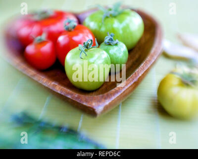 Eine hölzerne Platte mit Frische rote und grüne Tomaten Stockfoto