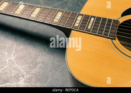 Akustische Gitarre auf grünem Marmor Hintergrund, Musik Konzept. Stockfoto