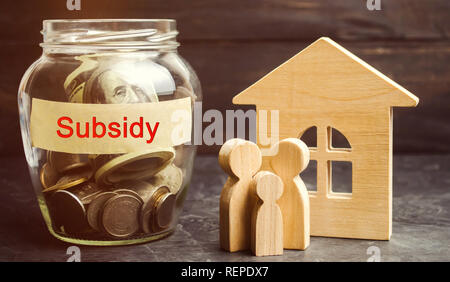 Die Familie ist in der Nähe von Glas mit der Aufschrift Subvention. Finanzielle Hilfen, die Unterstützung der Bevölkerung. Finanzielle Beihilfen, zinslose Darlehen. Steuern Stockfoto
