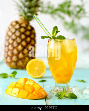 Eistee mit Mango und Ananas auf Blau blau Boards Stockfoto