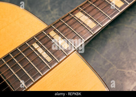 Akustische Gitarre auf grünem Marmor Hintergrund, Musik Konzept. Stockfoto