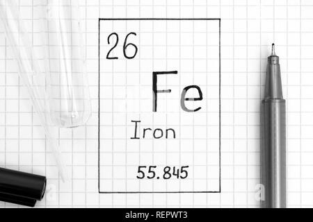 Das Periodensystem der Elemente. Handschrift chemische Element Eisen Fe mit schwarzem Stift, Reagenzglas und Pipette. Close-up. Stockfoto