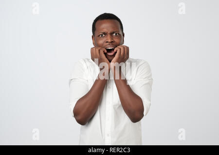 Afrikanischer Mann mit nervösen Ausdruck, beißt finger Nägel, sorgen vor dem Interview Stockfoto