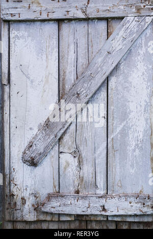 Blass und grau, weiß gestrichenen Holztür auf der Seite einer Scheune Stockfoto