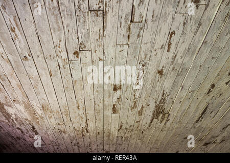 Close-up verblasster weiß lackiertem Holz beplankt mit Wasserflecken an der Decke in einem verwitterten alten Scheune Stockfoto