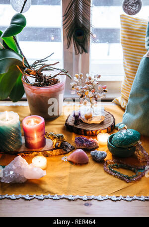 Feng Shui Thema Natur Altar zu Hause Tisch und auf der Fensterbank. Element Erde (Rock crystal Cluster), Holz (Holz-Scheiben), Element Feuer Stockfoto