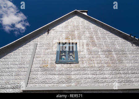 Seitenwand mit Fenster auf alten 1839 Silbermetallic geprägte Fliese mit blauen und weißen Zierleisten Außenlackierung Canadiana cottage Style home Stockfoto