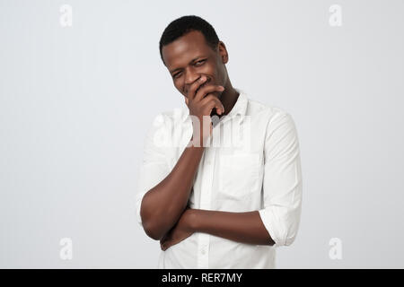 Sly , afrikanischer Mann Kinn Berühren mit dem Finger und Wegsehen. Hübscher Kerl denken. Stockfoto