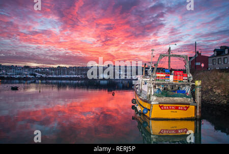 Crosshaven, Cork, Irland. 23. Januar, 2019. Eine atemberaubende rote Dämmerung Himmel über der Trawler keltische Sonne, die Gebunden wartet auf die Ebbe zu gehen, so dass die Besatzung maintaince Arbeiten am Rumpf in Crosshaven, Co Cork, Irland beginnen kann. Quelle: David Creedon/Alamy leben Nachrichten Stockfoto