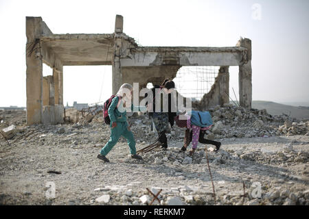 23 Januar 2019, Syrien, Jisr al-Shughur: Syrische Kinder spielen unter den Trümmern des beschädigten Al Kefir Schule an Jisr al-Shughur in der rebellischen Provinz Idlib gehalten. Mehr als 200 Schüler werden noch die Schule trotz der Zerstörungen durch die Luftangriffe, die von der syrischen Regierung zwischen 2015 und 2016 durchgeführt. Foto: Anas Alkharboutli/dpa Stockfoto