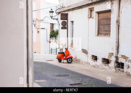 Barcelona, Spanien - 13. Januar 2018: Orange Scooter Vespa auf der alten Straße in Barcelona, Spanien geparkt Stockfoto