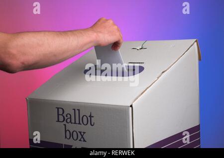 Hand ablegen Abstimmung in einer Wahlurne gegen Kulisse mit gegensätzlichen Farben des politischen Spektrums Stockfoto