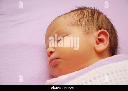 Eine Woche alt Baby schlafend unter decken Stockfoto