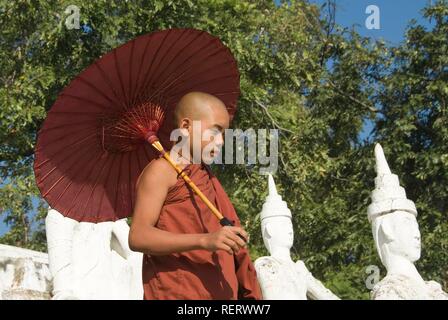 Junger buddhistischer Mönch mit einem roten Regenschirm, Settawya Pagode, Mingun, Burma, Myanmar, Südostasien Stockfoto