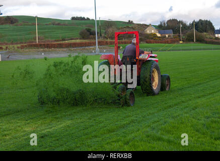 Mann auf einem Traktor, der beim Ziehen einer Bande Mäher Stockfoto