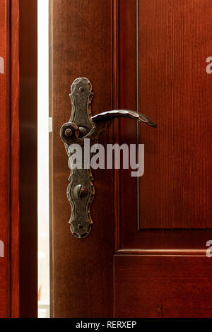 Reich verzierte Tür griff auf einem dunklen Holz Tür, öffnen Sie die Tür einen Spalt Stockfoto