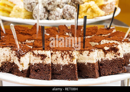 Köstliche Schokolade Biskuit mit Quark und Creme mit Kakao bestreut. Dessert Tisch in einem Cafe für Kinder Stockfoto