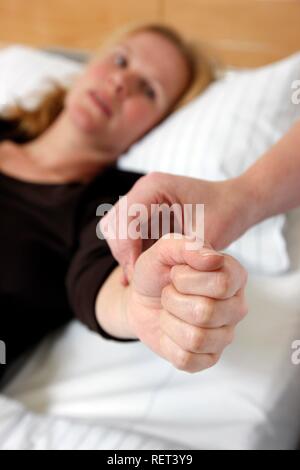 Krankenschwester Kontrolle der Puls eines Patienten in einem Krankenhaus Stockfoto
