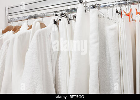 Weißer Bademantel mit Aufhängevorrichtung und Handtuch im Schrank im Zimmer. Schließen der Kleiderbügel und Bademantel im Schrank im Hotel. Stockfoto