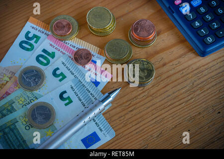 Komposition mit Banknoten und Münzen (Euro), Rechner auf hölzernen Hintergrund Stockfoto