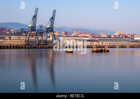 Krane entlang des Flusses Nervion im industriellen Norden von Bilbao, Baskenland, Spanien Stockfoto